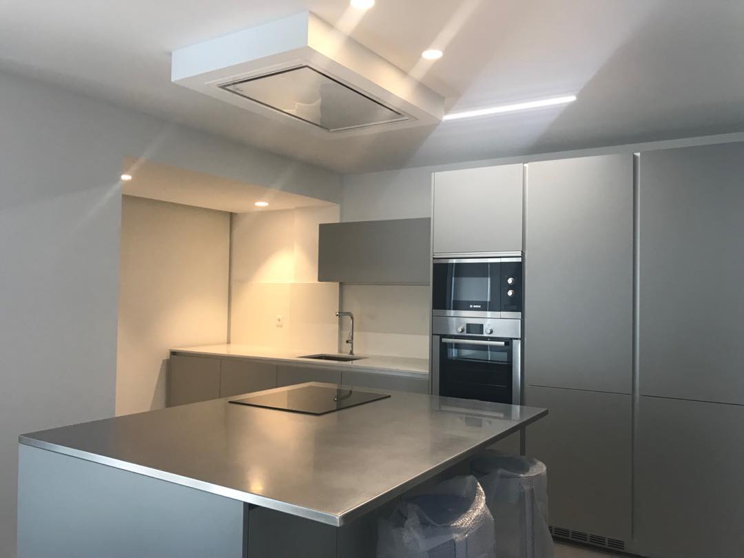 Cocina reformada con isla, encimera amplia y campana integrada en vivienda de San Juan Playa (Alicante).