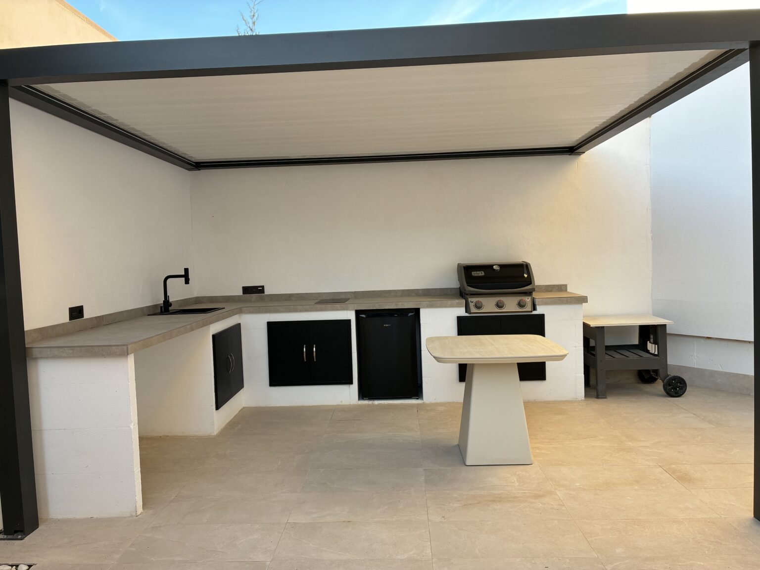 Cocina reformada con encimera amplia, isla central, fregadero y electrodomésticos en una distribución funcional.